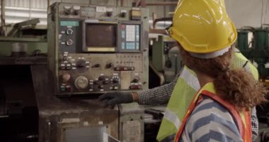 Fabrikadaki işçiler çalışmaya başlamadan önce eski makineyi açıklar ve kontrol ederler.