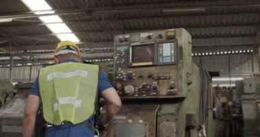 İşçi fabrikası fabrikadaki makineyi kontrol edip tamir ediyor..
