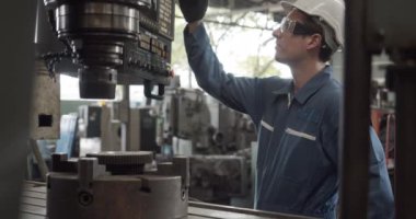 İşçi fabrikası fabrikadaki makineyi kontrol edip tamir ediyor..