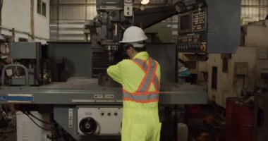 İşçi fabrikada eski makine araç ve okuma kılavuzu hazırlayın.