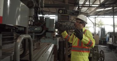 İşçi fabrikada eski makine araç ve okuma kılavuzu hazırlayın.