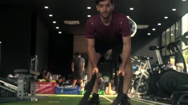 Genç erkek vücut geliştirici spor salonunda iple egzersiz yapıyor. Yavaş parola.