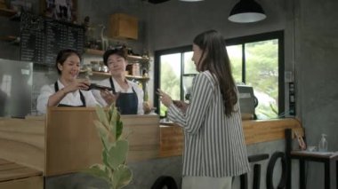 Genç Asyalı kadın bir kafede oturuyor ve dizüstü bilgisayarla çalışıyor..