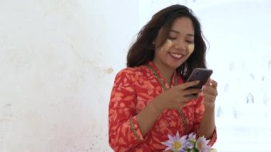Myanmar 'ın geleneksel Myanmar giysisi içinde Mingun Mandaley, Myanmar' daki Hsinbyume Pagoda 'da cep telefonu kullanıyor..