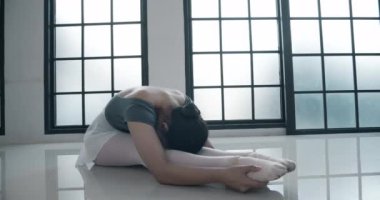 Stüdyoda bale yapan genç bir kadın.