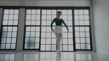 Stüdyoda bale yapan genç bir kadın.