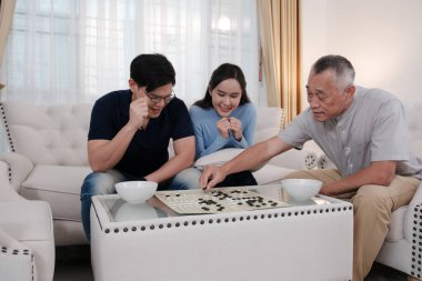 Mutlu Asyalı Aileler evde oyun oynamak için vakit geçiriyorlar..