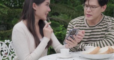 Bir çift Asyalı cep telefonuna baktığında çok mutlu olur.