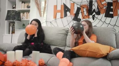 Çocuklar balon şişiriyor ve Cadılar Bayramı 'nı hazırlamak için eğlenceli bir şekilde eğleniyorlar. Balkabağı ve örümcek ağıyla süslenmiş bir şekilde..