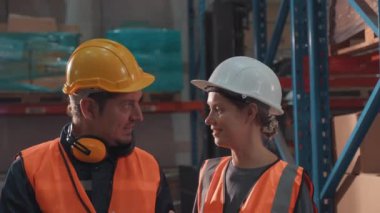 Bir grup endüstri işçisi depo fabrikasında çalışıyor ve tartışıyorlar..