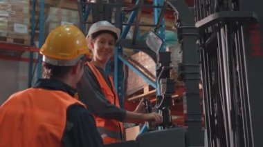 Bir grup endüstri işçisi depo fabrikasında çalışıyor ve tartışıyorlar..