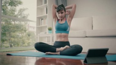 Sabahları evde yoga egzersizi yapan genç bir kadın.