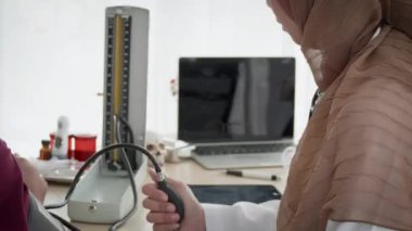 Hastanede Müslüman bir hastayı muayene eden Müslüman kadın doktor. Sağlık ve Tıp Konsepti.