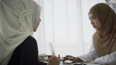 Hastanede Müslüman bir hastayı muayene eden Müslüman kadın doktor. Sağlık ve Tıp Konsepti.