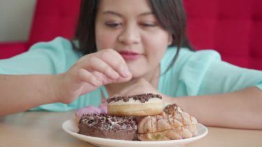 Kilolu kadın donut yemekten hoşlanır.