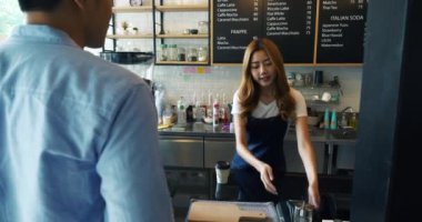 Barista müşterilere kahve servisi yapıyor ve sonra cep telefonu, E-ödeme hizmeti konseptiyle kahve alıyor.. 