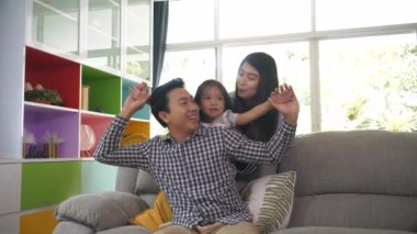 Mutlu Asyalı aile evde birlikte rahatlamak için zaman geçiriyor.