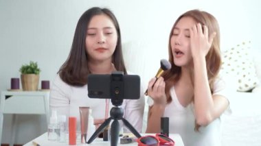 İki güzel kadın vlogger veya blogger sunar fırça ve kozmetik sosyal medyaya canlı video yayınlar. 