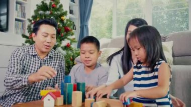 Mutlu Asyalı aile evde birlikte rahatlamak için zaman geçiriyor.