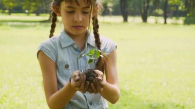 Genç kızın ellerini kapat. Genç bitkiyi yaşlı ellerinden al ve gülümse..