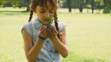 Genç kızın ellerini kapat. Genç bitkiyi yaşlı ellerinden al ve gülümse..