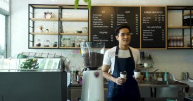 Barista kahvecide kahve servisi yapıyor ve gülümsüyor..