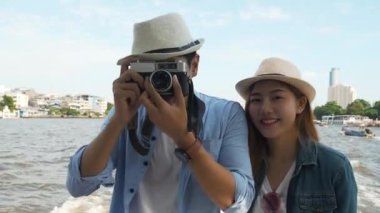 Bangkok, Tayland 'da Chao Pra Ya Nehri' nde fotoğraf çeken Asya 'lı çift, tekne gezisi için Bangkok' a seyahat ediyor..
