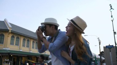 Genç bir çift turist Wat Pho ve Royal Palace 'ı gezip fotoğraf çekiyorlar ve Bangkok Tayland' da gün batımında Wat Arun 'u izliyorlar.