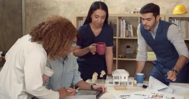 Şirket ekibi iş arkadaşlarıyla çalışıyor, toplantı yapıyor ve modern ofiste rahatlıyor.. 