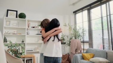 İki genç Asyalı kadın birbirini kucaklıyor..