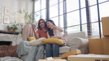 Kanepede oturan birkaç Asyalı kadın selfie gülümsemesi ve mutluluk için cep telefonu kullanıyor.