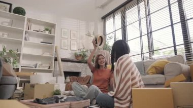 İki genç Asyalı kadın yastıkları kapıp oynaşıyor..