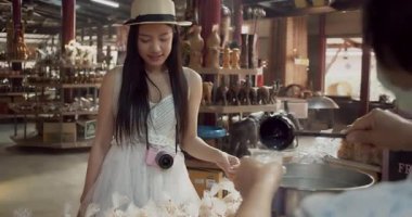 Genç Asyalı bayan turist Palm juice 'u test ediyor ve Damnoen Saduak Yüzen Market Tayland' da Palm juice 'a bakıyor..