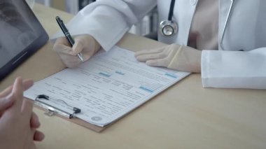 Asyalı erkek doktor hastanedeki Asyalı kadın hastanın röntgen testini yapıyor.