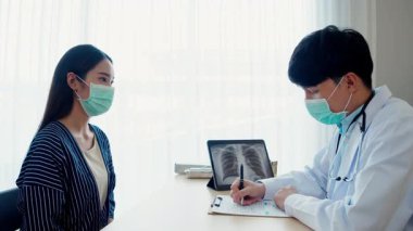 Asyalı erkek doktor hastanedeki Asyalı kadın hastanın röntgen testini yapıyor.