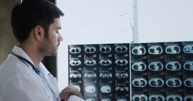 Erkek doktor röntgen filmini izliyor ve hastanede muayene ediyor.