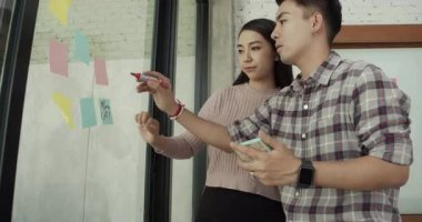 Ofiste toplanan meslektaşlar fikir paylaşımı yapmak için tahtaya yazı yazıyorlar..