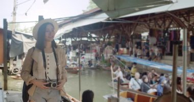 Tekneyle Tayland yemeği yiyen Asyalı turist kadın ve Damnoen Saduak kanalı boyunca seyahat eden yüzen pazar ratchaburi thailand