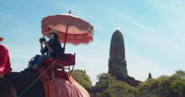 Asyalı kadın turistler fil kamplarını ziyaret ediyor ve Ayutthaya 'da fillere biniyorlar..