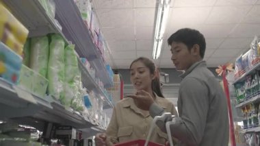 Müşteri dükkandaki alışveriş arabasına ürün ekliyor.