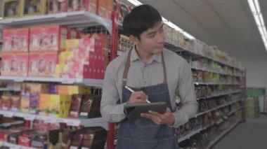 Çalışanlar bir mağazadaki ürünleri sınıflandırıyor ve kontrol ediyorlar.