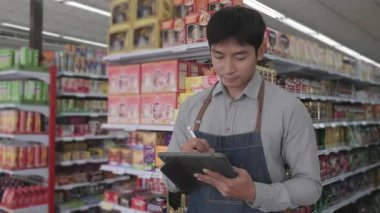 Çalışanlar bir mağazadaki ürünleri sınıflandırıyor ve kontrol ediyorlar.