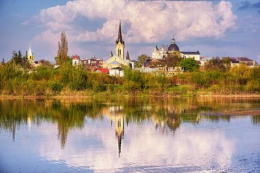 Yaz manzarası - kilise, tapınak ve güneşli bir günde park olan nehir kıyısı (Lutsk, Ukrayna).