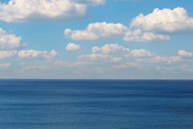 Yaz manzarası - mavi deniz ve kümülüs bulutları güneşli bir günde üzerlerinde.