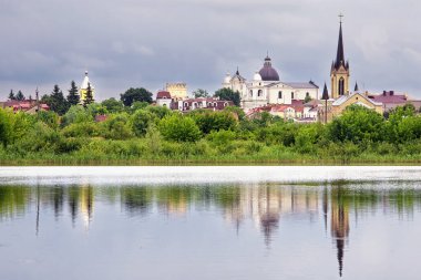Yaz manzarası - kiliseleri, tapınakları ve bulutlu bir günde parkı olan nehir kıyısı (Lutsk, Ukrayna).