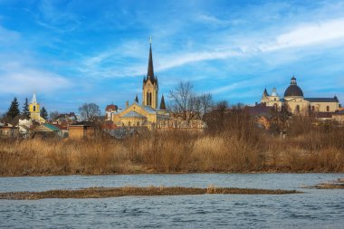 Bahar manzarası - Kiliseler, tapınaklar ve bulutlu bir günde park edilen nehir kıyısı (Lutsk, Ukrayna)).