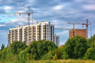 Parkın sınırındaki yüksek binaların vinçleriyle inşa ediliyor..