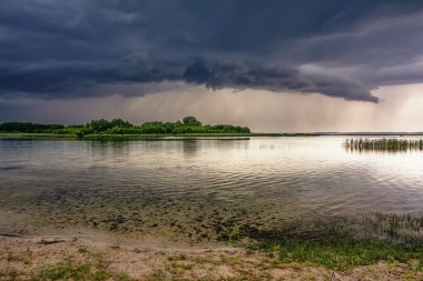 Yaz manzarası - fırtına bulutları ve yağmur göl ve kıyıları üzerinde.