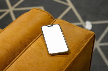 Çalışan masa ve deri koltukta parola sayfası olan cep telefonu.