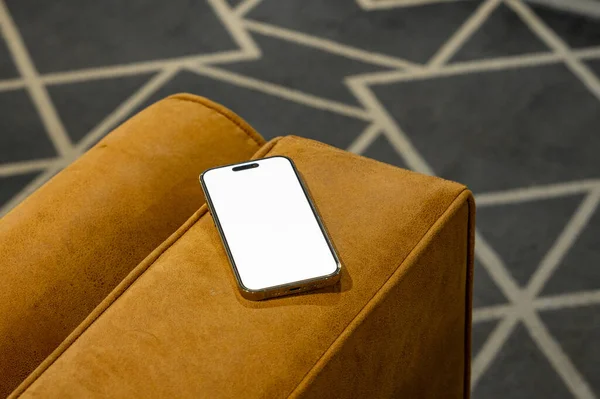 Çalışan masa ve deri koltukta parola sayfası olan cep telefonu.